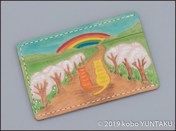 牛革の作品「虹と猫のパスケース（定期入れ）」虹と桜の木をモチーフにした図案